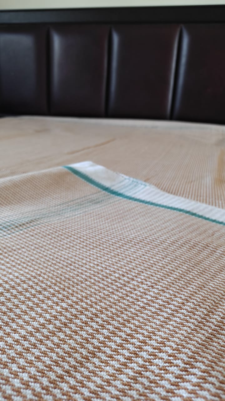 Khaki cotton khes handwoven double‑cloth throw in Majnu pattern, spread out to show texture and fringed edges.