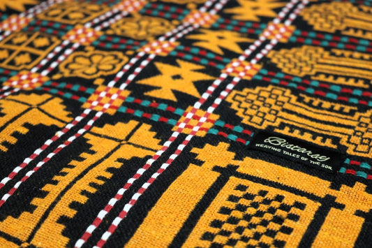 Close-up of a colorful khes fabric with geometric patterns and a brand label.