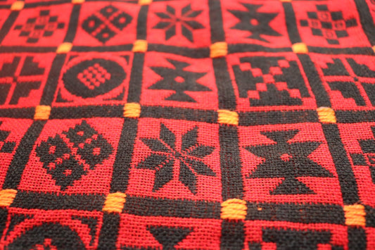 Red and black geometric patterned fabric with yellow accents