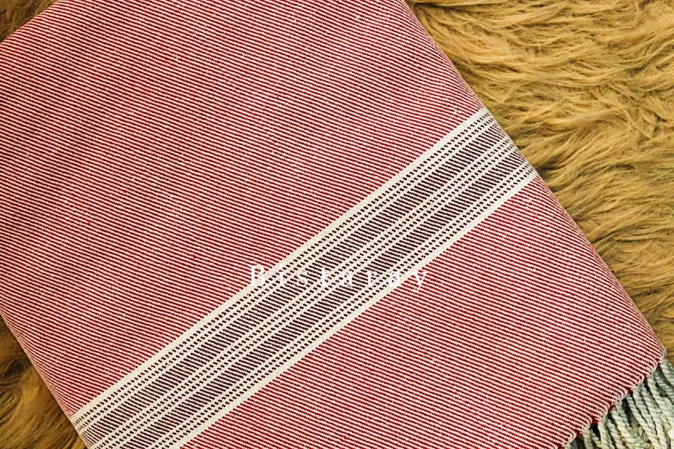 Red and white striped towel on a wooden surface