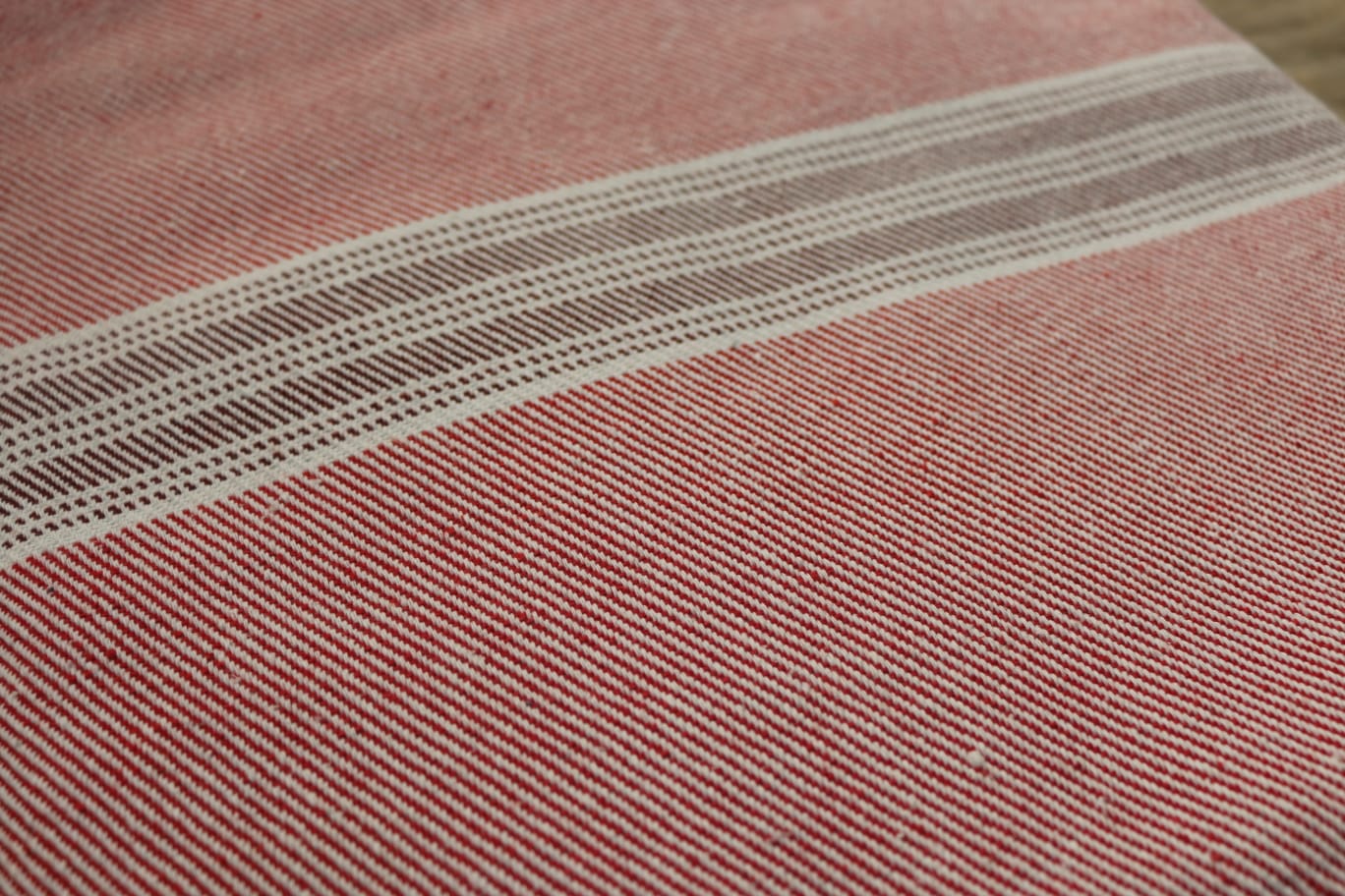 Close-up of a textured fabric with horizontal stripes on a pink background