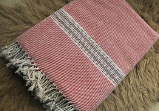 Pink towel with white stripes on a brown textured surface