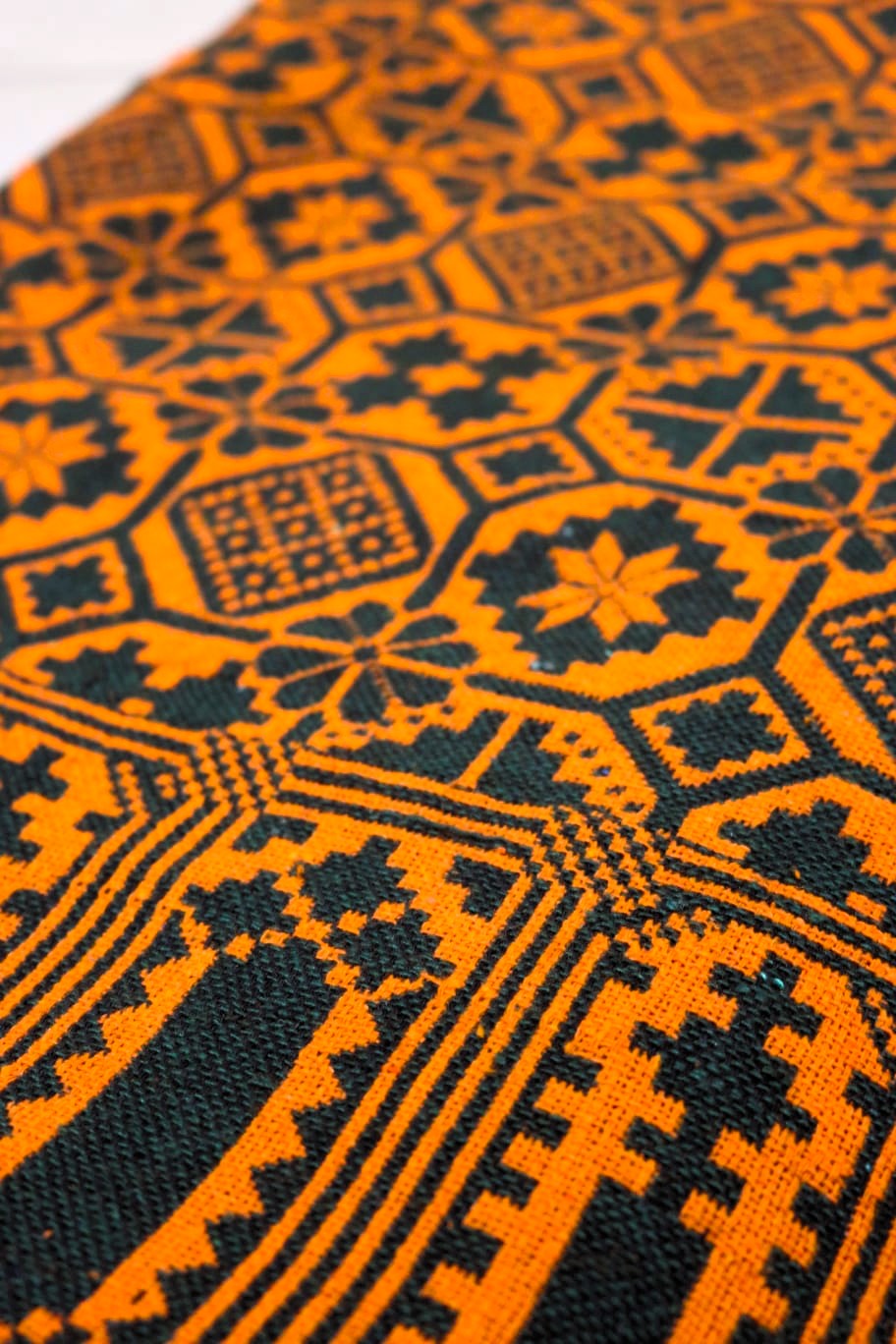 Close-up of an orange and green geometric patterned fabric.