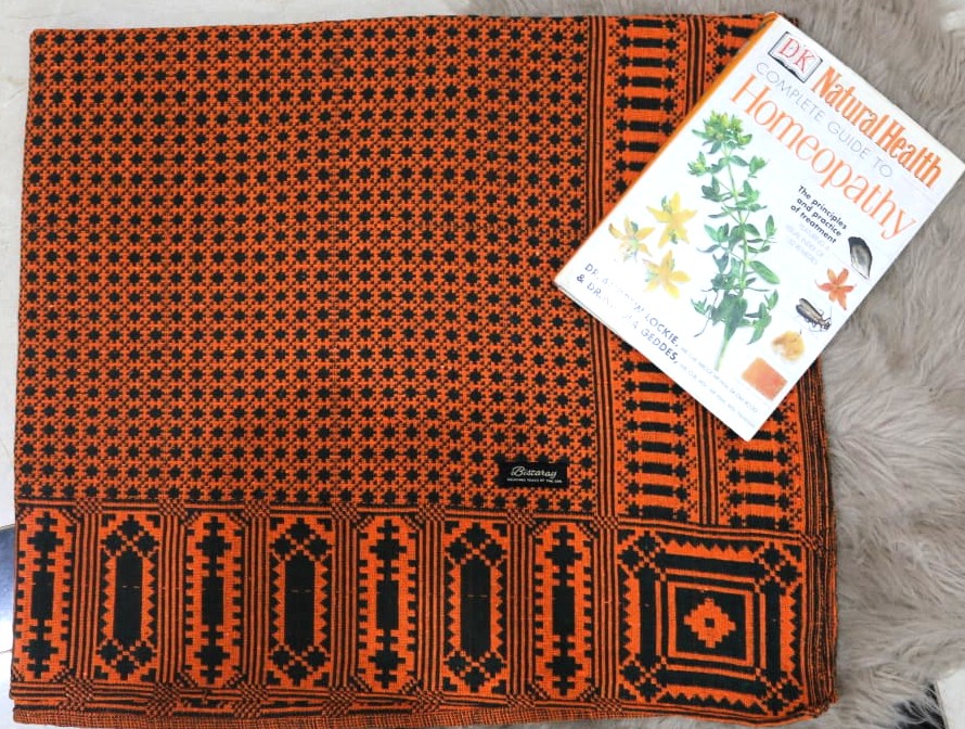 Patterned khes/khais  orange and black fabric with a magazine on top
