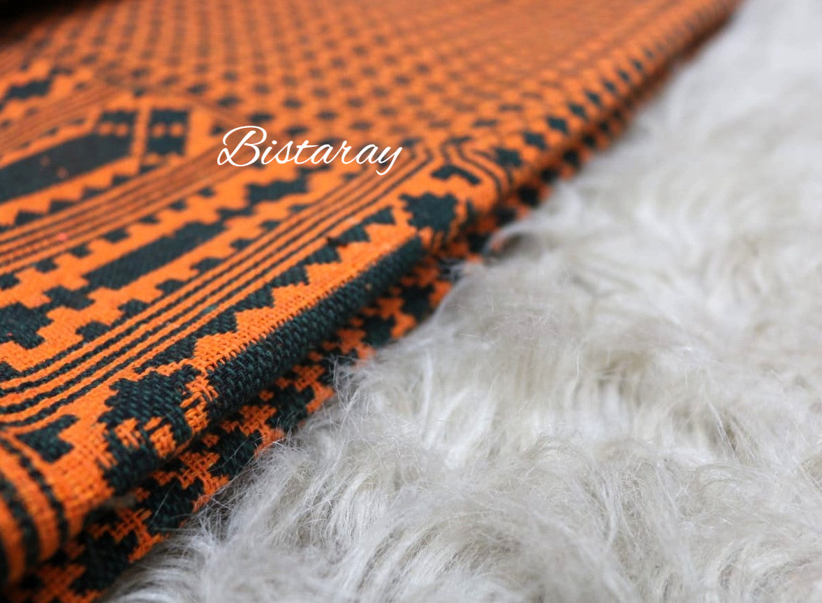 Orange and black patterned khes fabric with 'Bistaray' branding on a white fur background