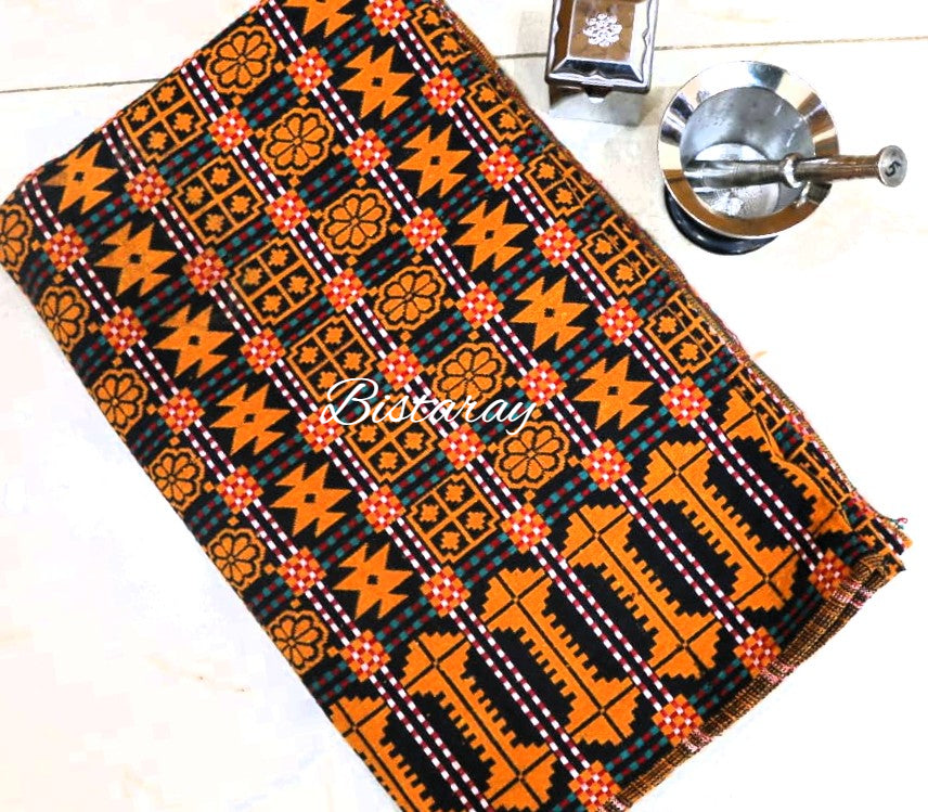 African/Pakistani khes weaved  print fabric with orange and black patterns on a white surface, featuring the brand 'Bistaray'.