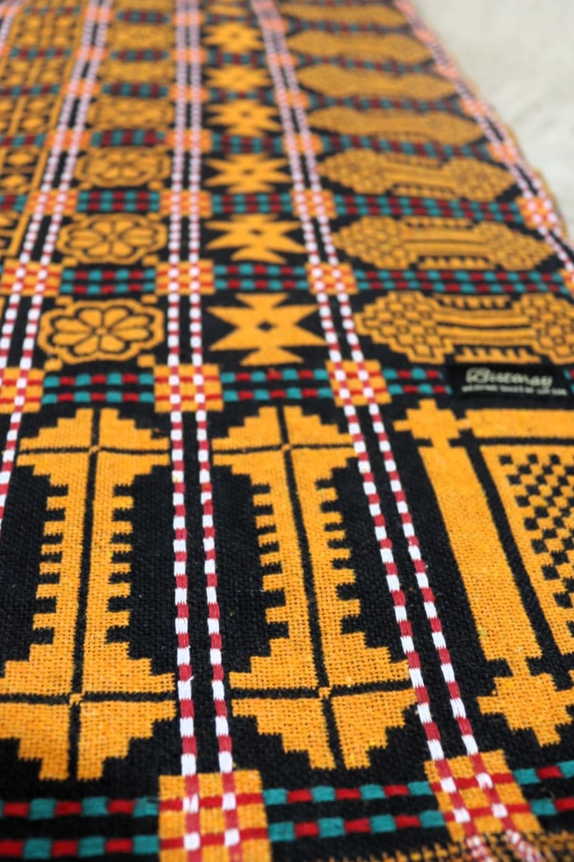 Textile with geometric pattern featuring yellow, black, and red colors.
