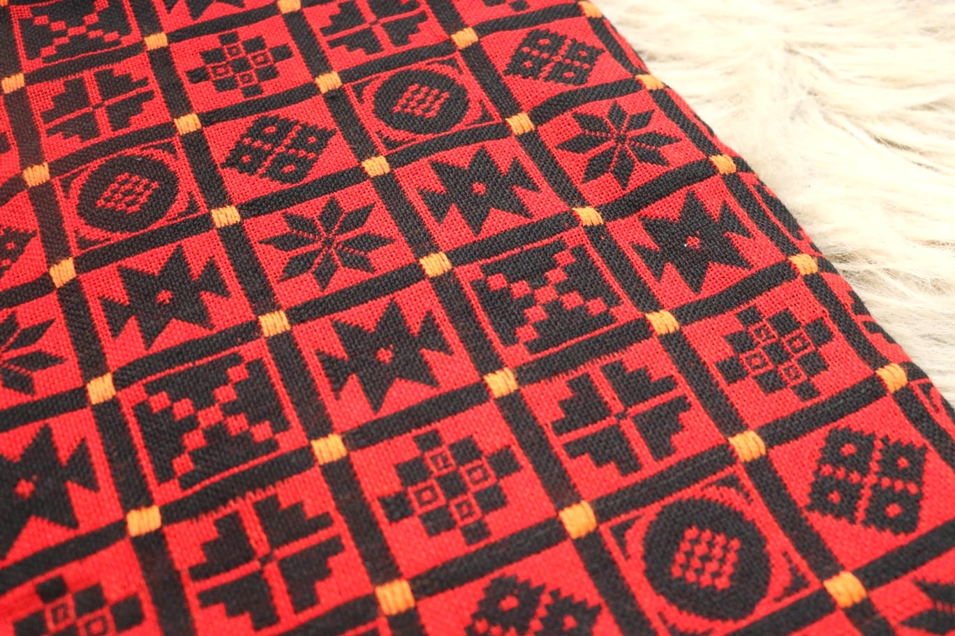Red and black geometric patterned fabric on a white background